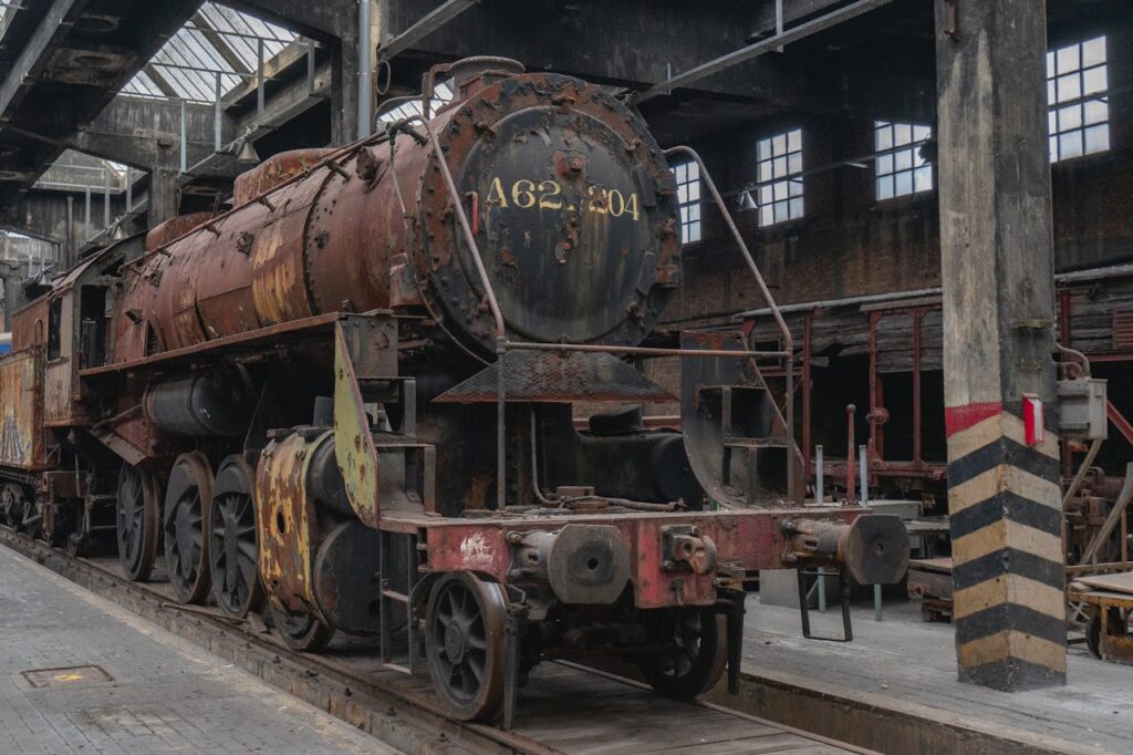 Rusty vintage steam locomotive in an abandoned train shed